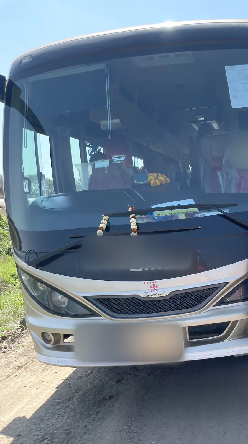 Mini bus front with a marigold garland across the bumper