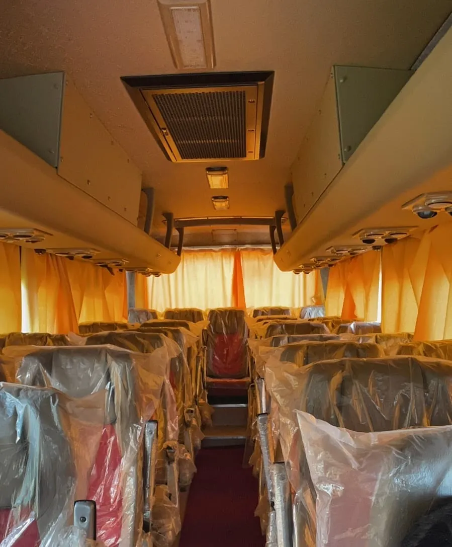 Interior of a new bus with seat covers still wrapped