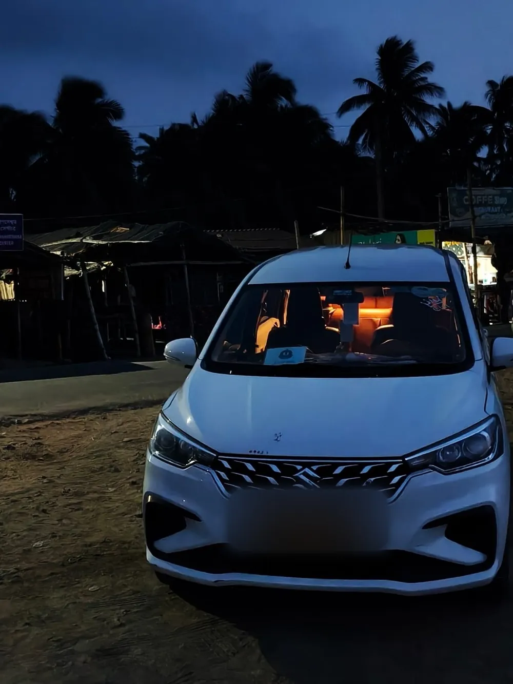 White Ertiga MUV parked at dusk