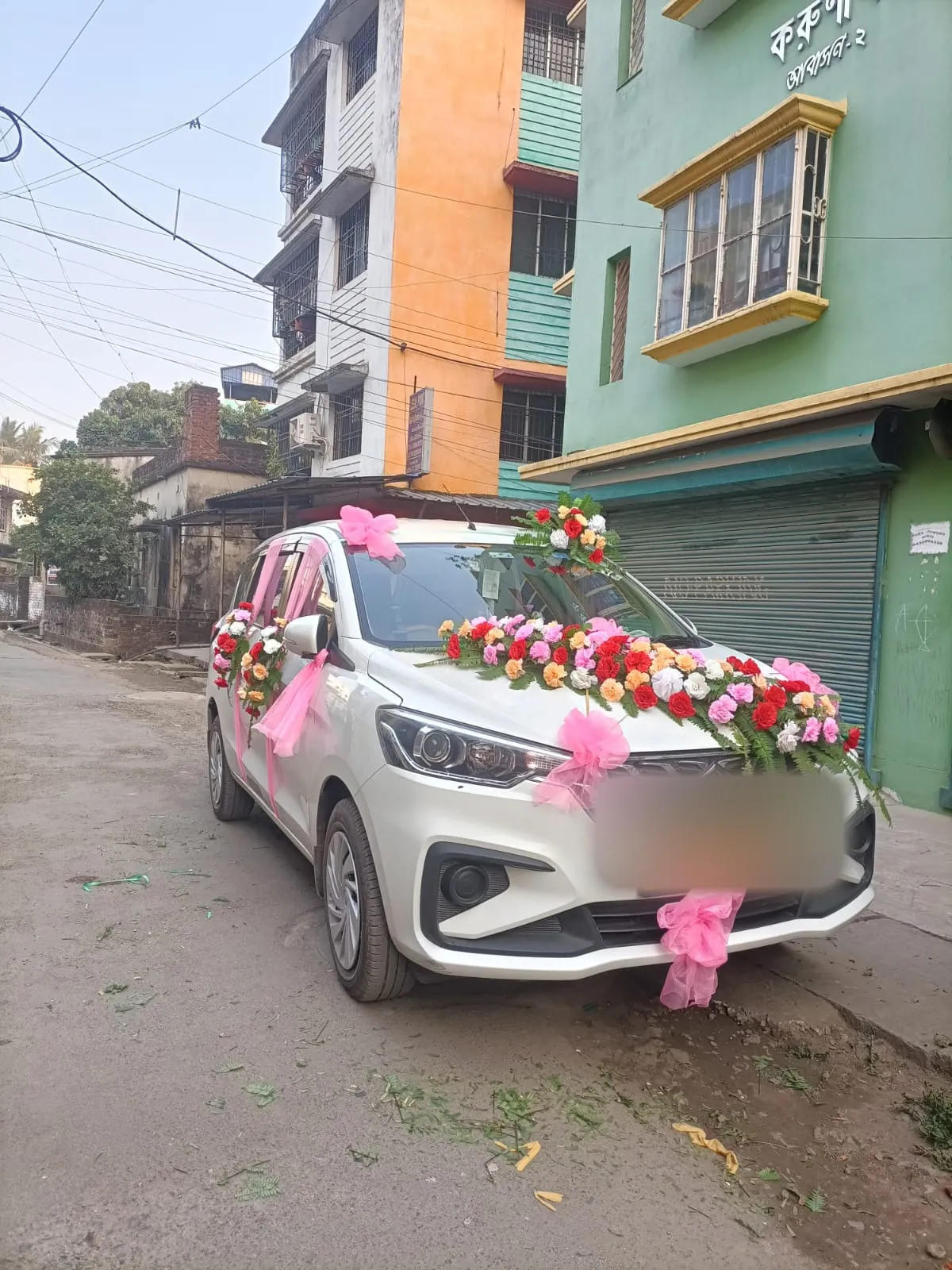 Decorated white MUV with flower garlands on the bonnet